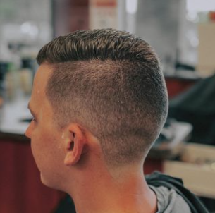 man in barbers chair getting hair cut