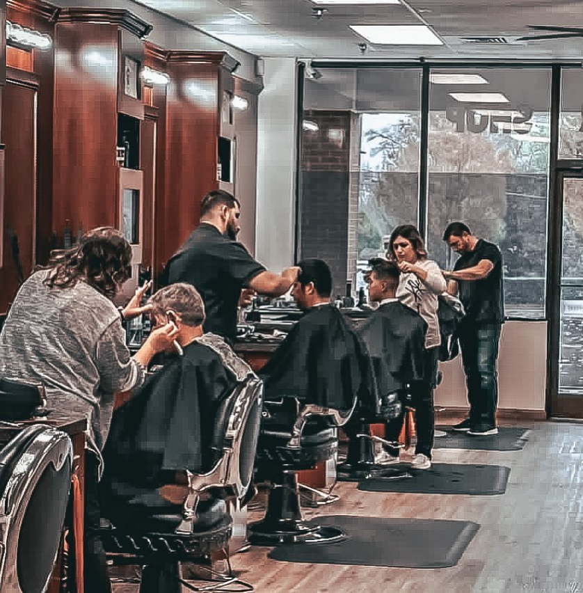 barbers cutting clients hair in barbershop