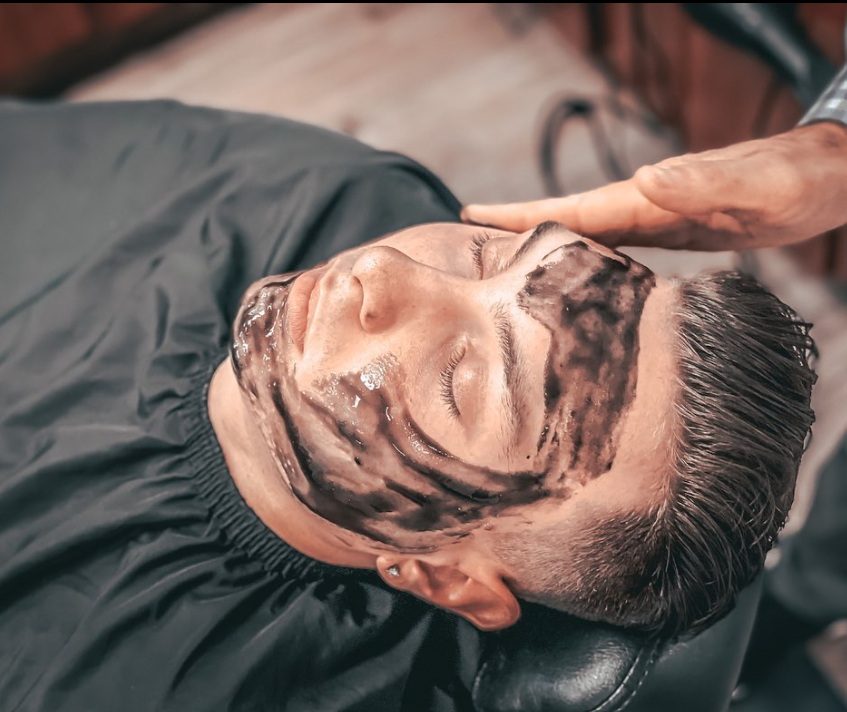 man in barbershop getting a facial
